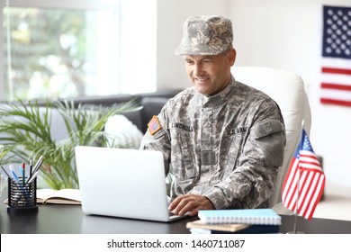 Mature male soldier working with laptop in headquarters building - Powered by Shutterstock