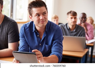 Mature Male Student With Digital Tablet In Adult Education Class