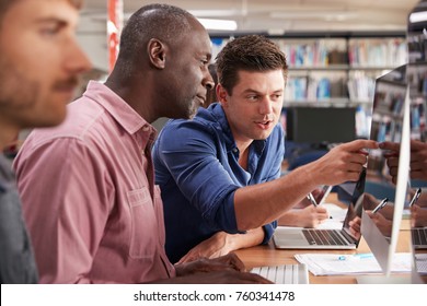 Mature Male Student With Tutor Learning Computer Skills