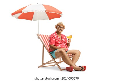 Mature Male Tourist Sitting In A Chair With A Cocktail Under Umbrella Isolated On White Background