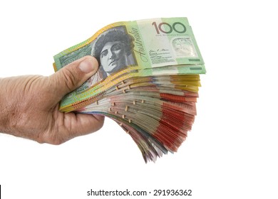 A mature males hand holding a large wad of Australian dollars in every denomination.