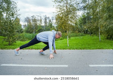 Mature man athlete at the start of a running track. - Powered by Shutterstock