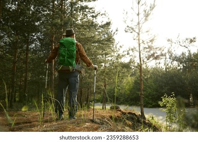 Mature man backpacker enjoying life trekking to explore outdoors