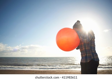 Mature Man Blowing Up Inflatable Hopper At Beach