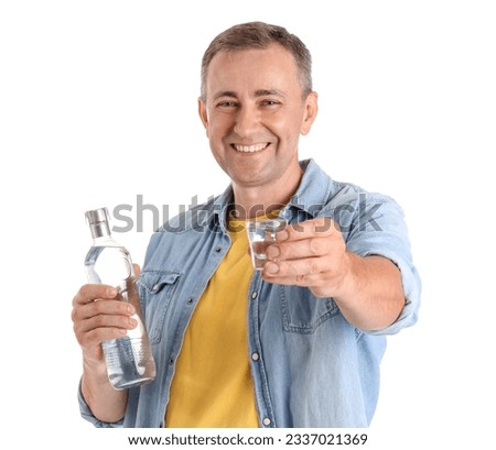 Mature man with bottle and glass of vodka on white background