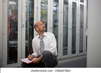 Mature man checking computers in server room