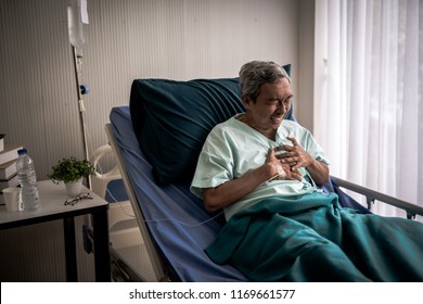 Mature Man With Chest Pain Suffering From Heart Attack In Hospital Bed.