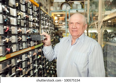 Mature Man Chooses Fasteners In  Auto Parts Store