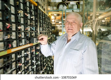 Mature Man Chooses Fasteners In  Auto Parts Store