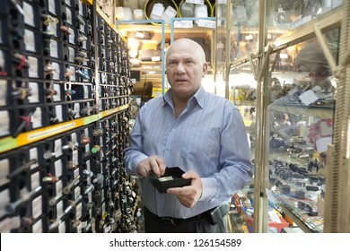 Mature Man Chooses Fasteners In  Auto Parts Store