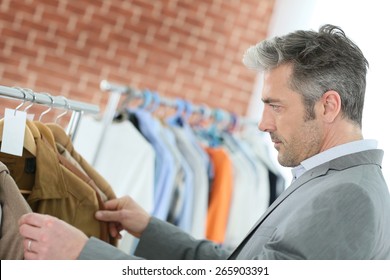 Mature Man Choosing Clothes In Shop