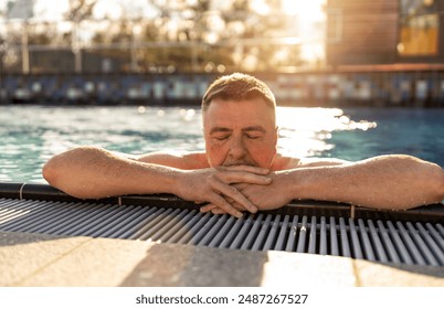 Mature man with closed eyes, resting arms on pool edge for relaxing in a hotel, sunlit water sparkling around him. Spa, retreat, relaxation and Beauty and body care concept image  - Powered by Shutterstock