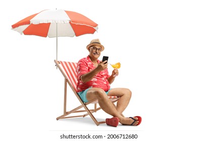 Mature Man With A Cocktail And A Mobile Phone Sitting On A Beach Chair Under Umbrella Isolated On White Background