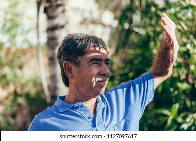 Mature Man Covering Face By Hand Of Bright Sun Light