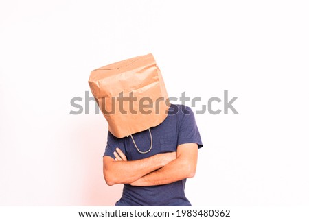 Mature man crestfallen, hiding his identity behind a paper bag over his head.