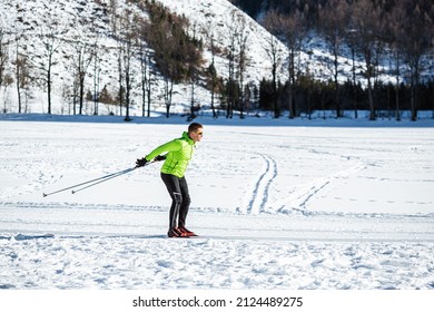 Mature Man Cross Country Skiing, On The Ski Trail Surrounded By Mountains And Forest.