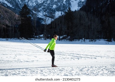 Mature Man Cross Country Skiing, On The Ski Trail Surrounded By Mountains And Forest.