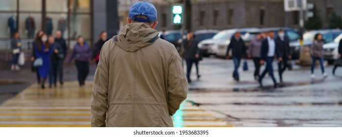 Mature man crossing street. Back, rear view. Green light of the stoplight. Crowd of people at other side of road. Urban lifestyle concept.  - Powered by Shutterstock