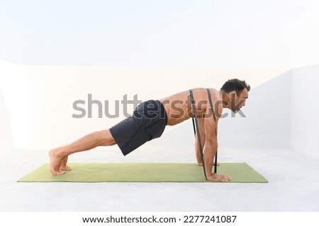 Mature man doing push-ups with elastic band