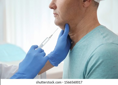 Mature Man With Double Chin Receiving Injection In Clinic, Closeup