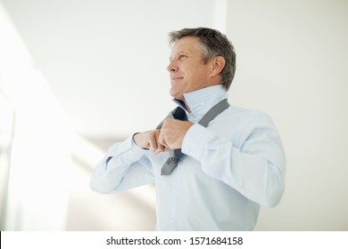 Mature Man Dressing In Shirt And Tie