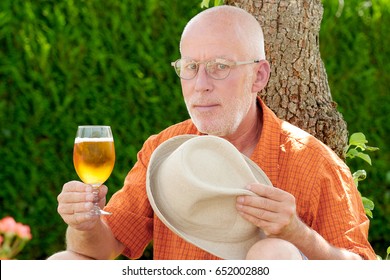 A Mature Man Drinking A Beer Outside