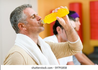 Mature Man Drinking Energy Drink During A Break At Gym