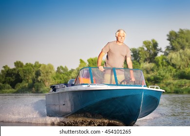 Mature Man Driving Motor Boat.