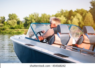 Mature Man Driving Motor Boat.