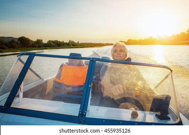 Mature Man Driving Motor Boat.