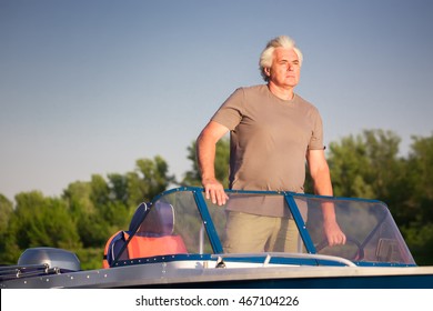 Mature Man Driving Motor Boat.