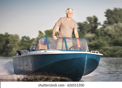 Mature Man Driving Motor Boat.