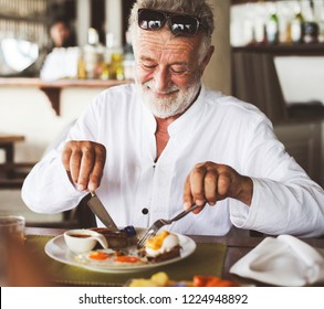 Mature Man Eating Breakfast At Hotel