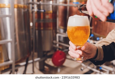 Mature man examining the quality of craft beer at brewery. Inspector working at alcohol manufacturing factory checking beer. Man in distillery checking quality control of draught beer - Powered by Shutterstock