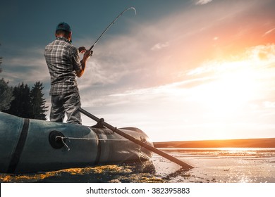 Mature Man Fishing On The Lake From Inflatable Boat