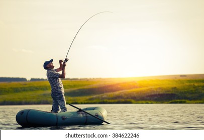 Mature Man Fishing On The Lake From Inflatable Boat