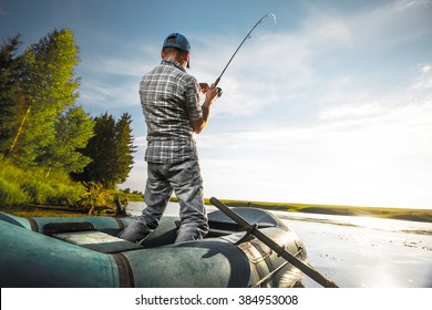 Mature Man Fishing On The Lake From Inflatable Boat