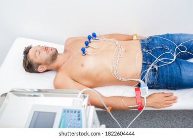 Mature Man Getting Electrocardiogram In A Hospital Room. Procedure ECG In Clinic