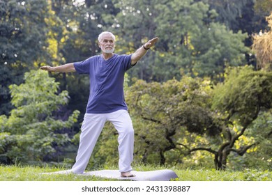 A mature man with gray hair is performing Tai Chi outdoors, demonstrating balance and focus in a tranquil park. - Powered by Shutterstock