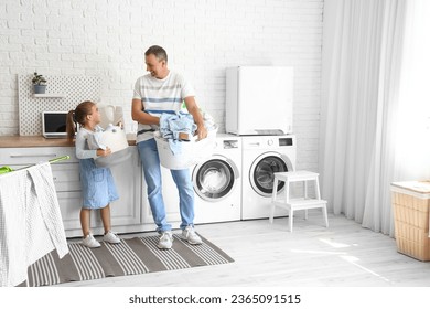 Mature man and his little granddaughter with laundry baskets at home - Powered by Shutterstock