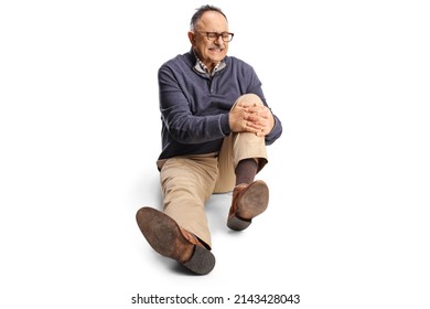 Mature man holding his painful knee and sitting on the floor isolated on white background - Shutterstock ID 2143428043