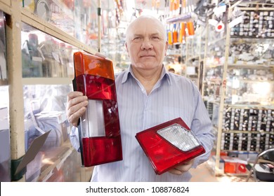 Mature Man Holds  Automotive  Headlight  In  Auto Parts Store