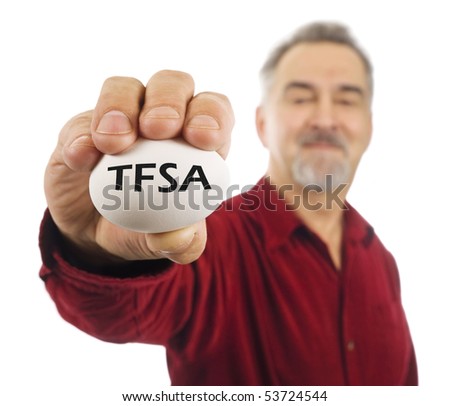 Mature man holds a white nest egg with TFSA (tax free savings account popular in Canada) on it.