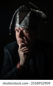 Mature man in a jester's cap portrait on black background