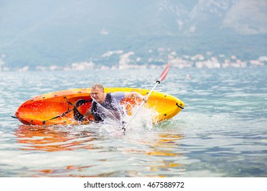 Mature Man Kayaking On The Sea, Falling Out Of The Kayak