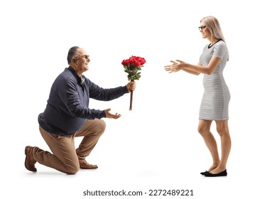 Mature man kneeling and giving a bunch of red roses to a young woman isolated on white background