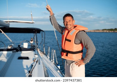 Mature man in a life jacket on a yach feeling good
