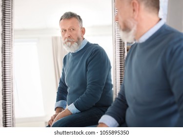 sad man looking in the mirror