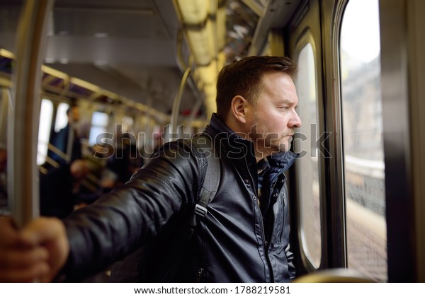 Mature man looks out the window of\
the car in the subway in new York. Transport of New\
York.