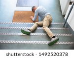 Mature Man Lying On Staircase After Slip And Fall Accident